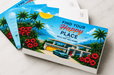 Stack of custom printed 24pt recycled uncoated postcards featuring colorful tropical real estate artwork with palm trees. Printed by Clubcard Palm Springs