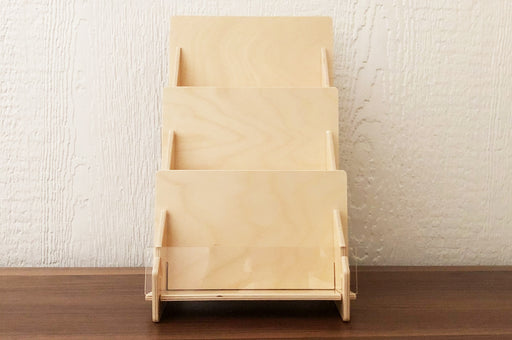 3-tier birch plywood card display stand with front acrylic panel on a wooden table.