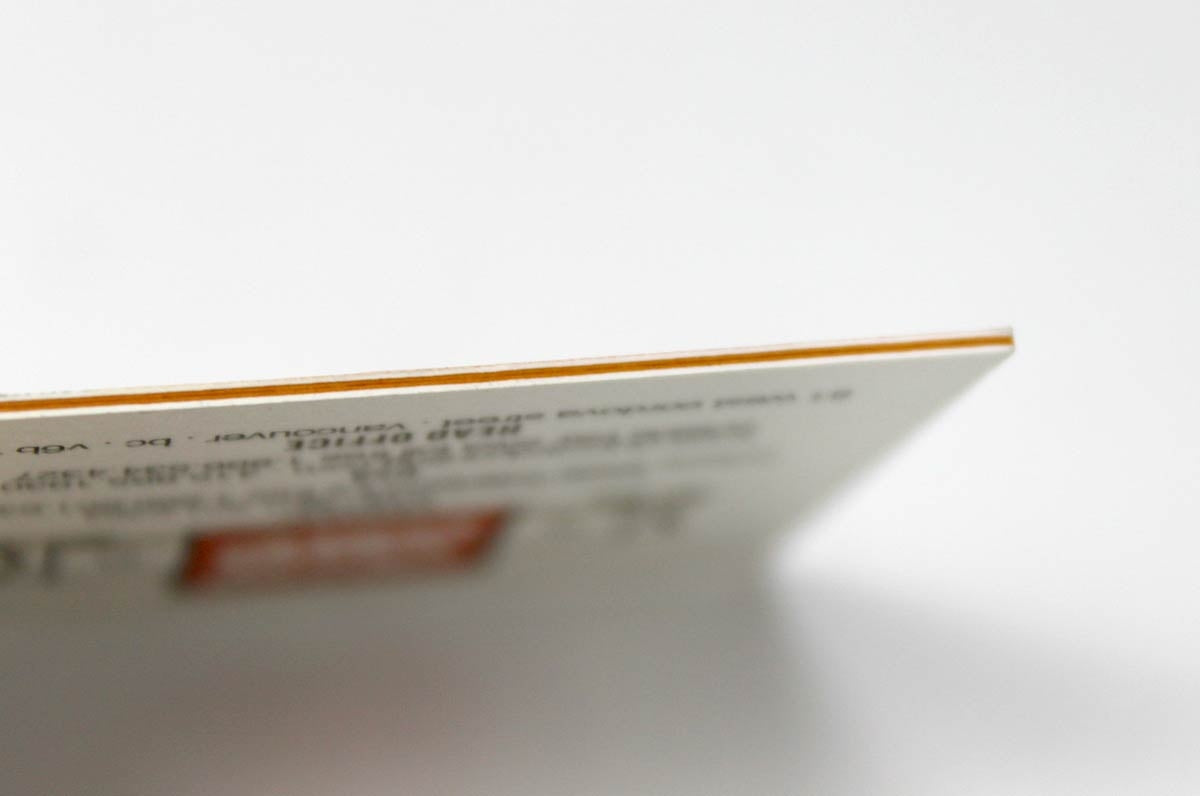 Close up showing the orange color core layer of our 37pt Uncoated Color Core stock | Clubcard Printing USA