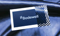 Custom business card for Bodewell printed on silk laminated 19pt stock with blue foil in a wavy pattern on the right third of the card | Clubcard Printing USA