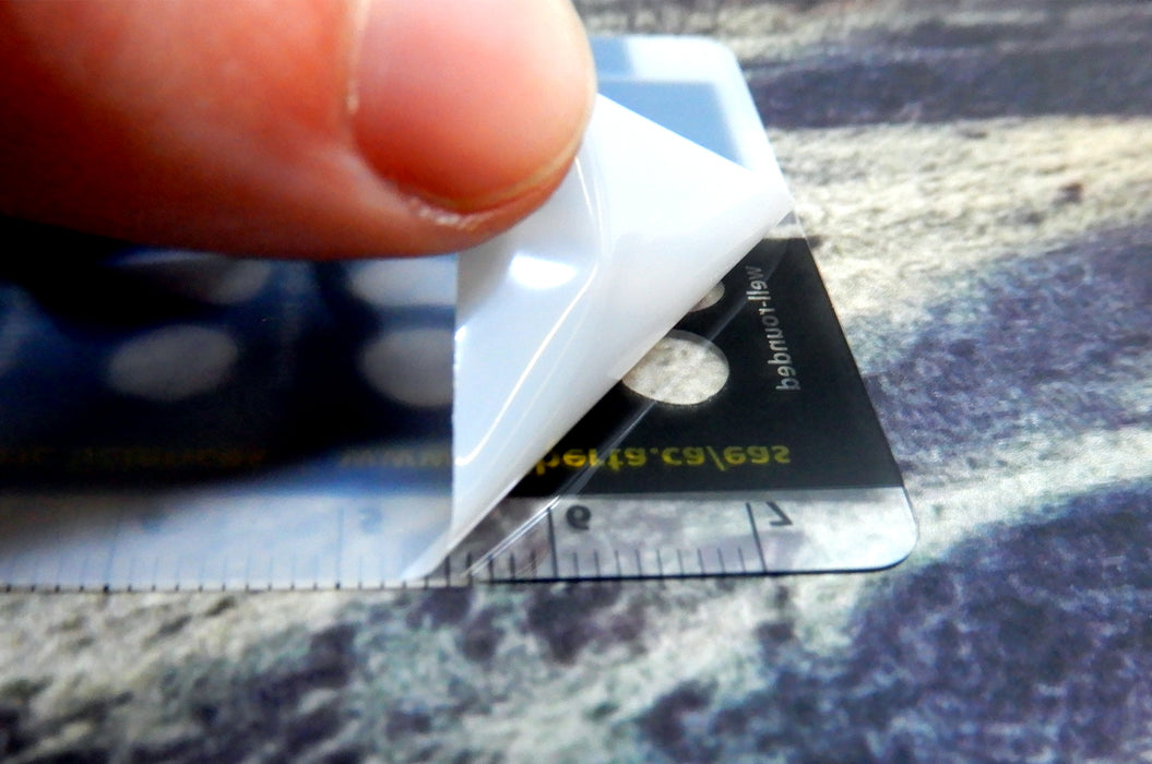 Showing the protective film being peeled off the back for the 20pt clear plastic cards | Clubcard Printing USA