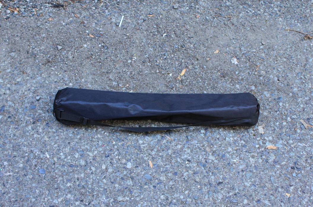 Black transportation bag for folding aluminum easel stand on concrete grey background.